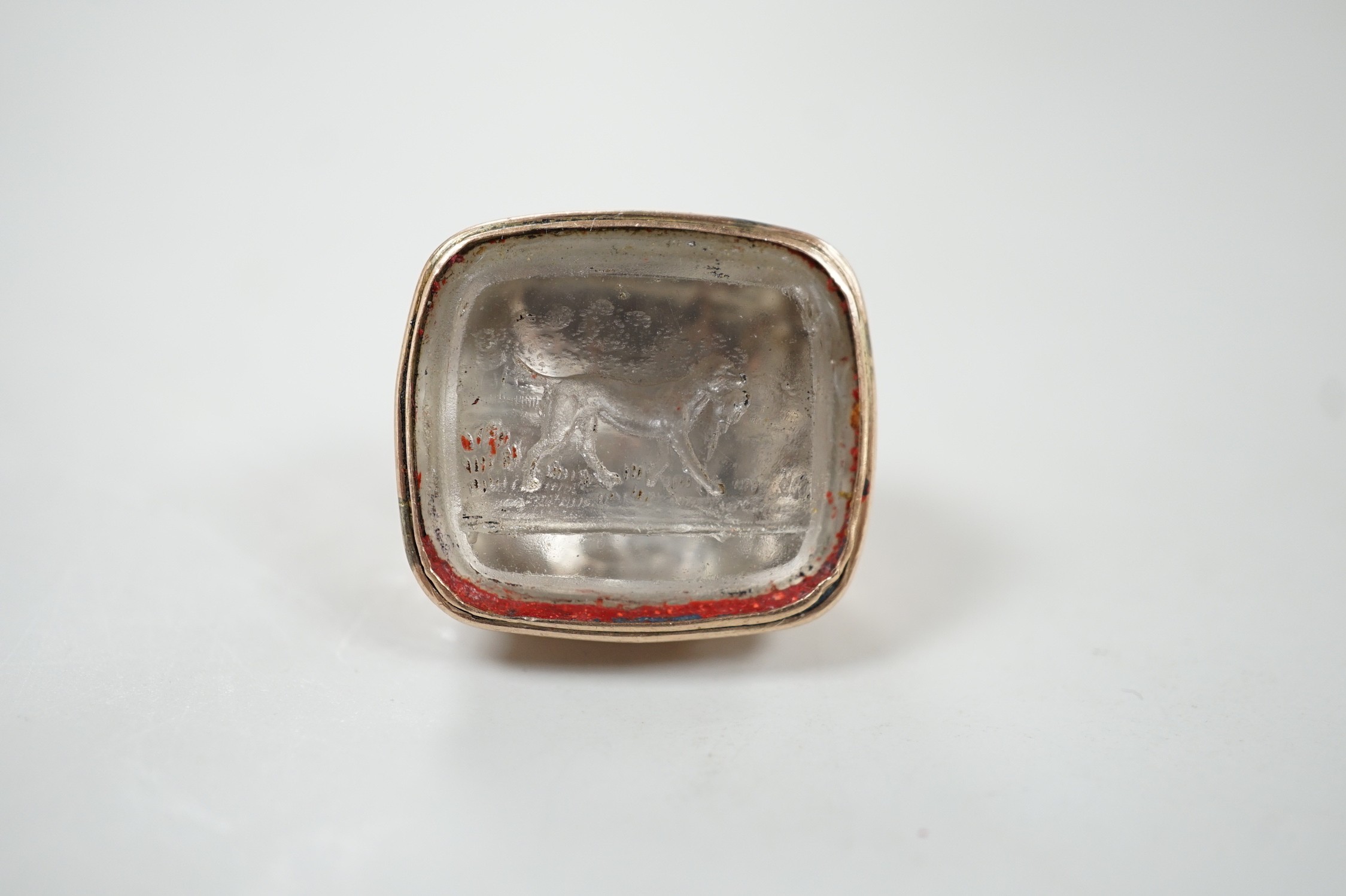 A 19th century gold plated and rock crystal? set fob seal, the matrix carved with hunting dog carrying prey, 24mm.